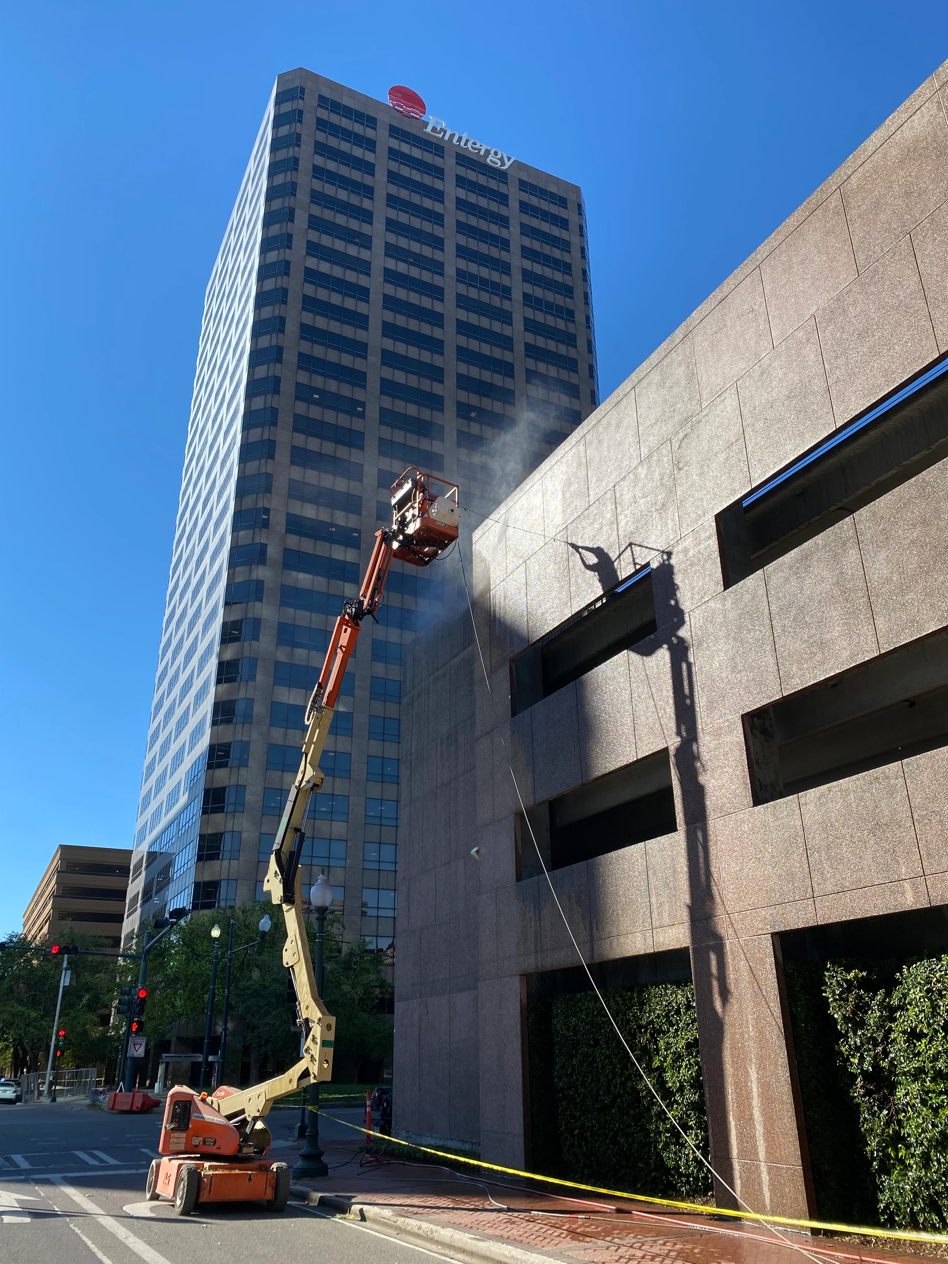 Commercial pressure washing and soft washing New Orleans — boom lift cleaning Entergy Centre building exterior