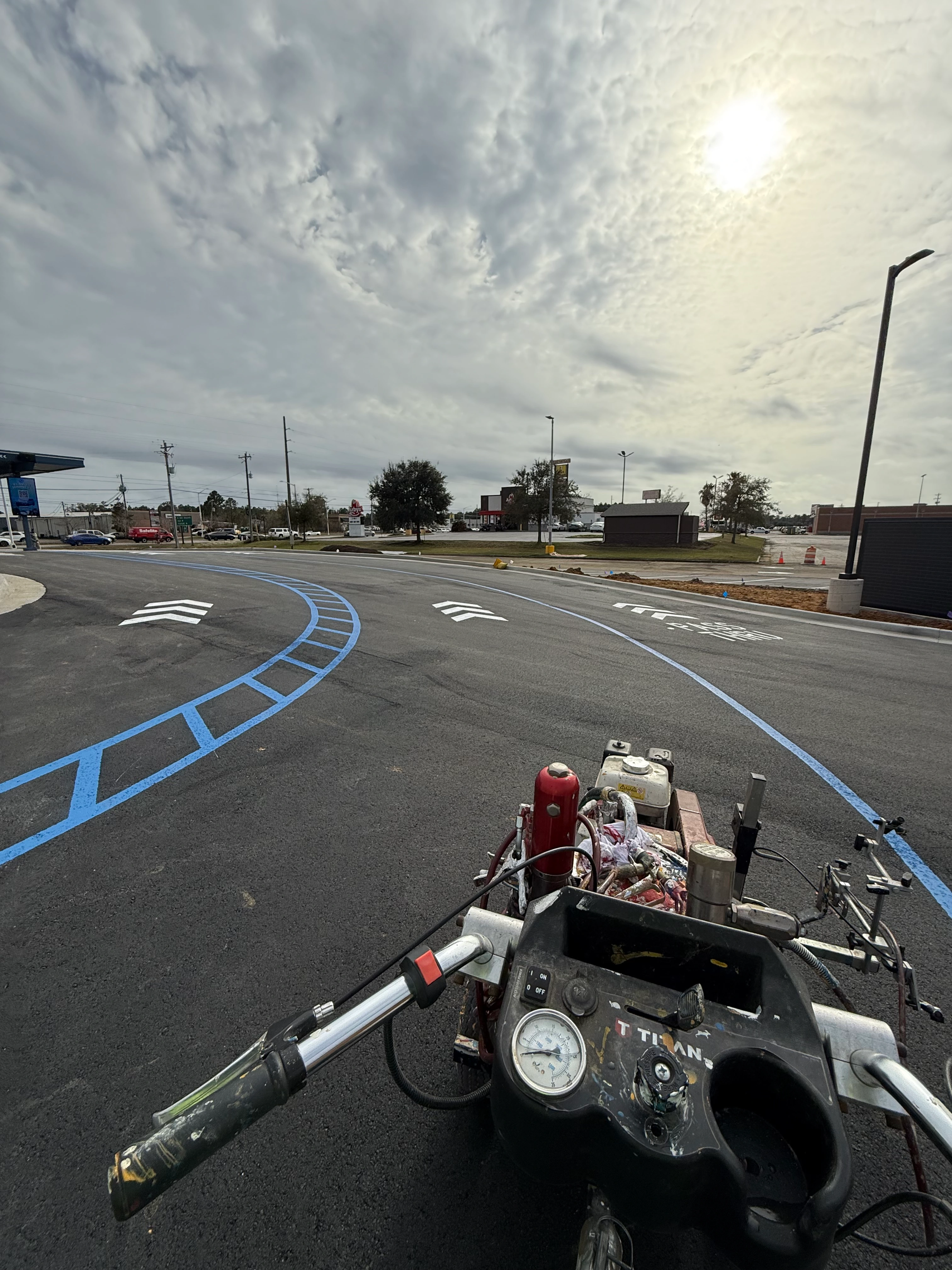 Parking lot striping New Orleans — line striping machine laying blue lines